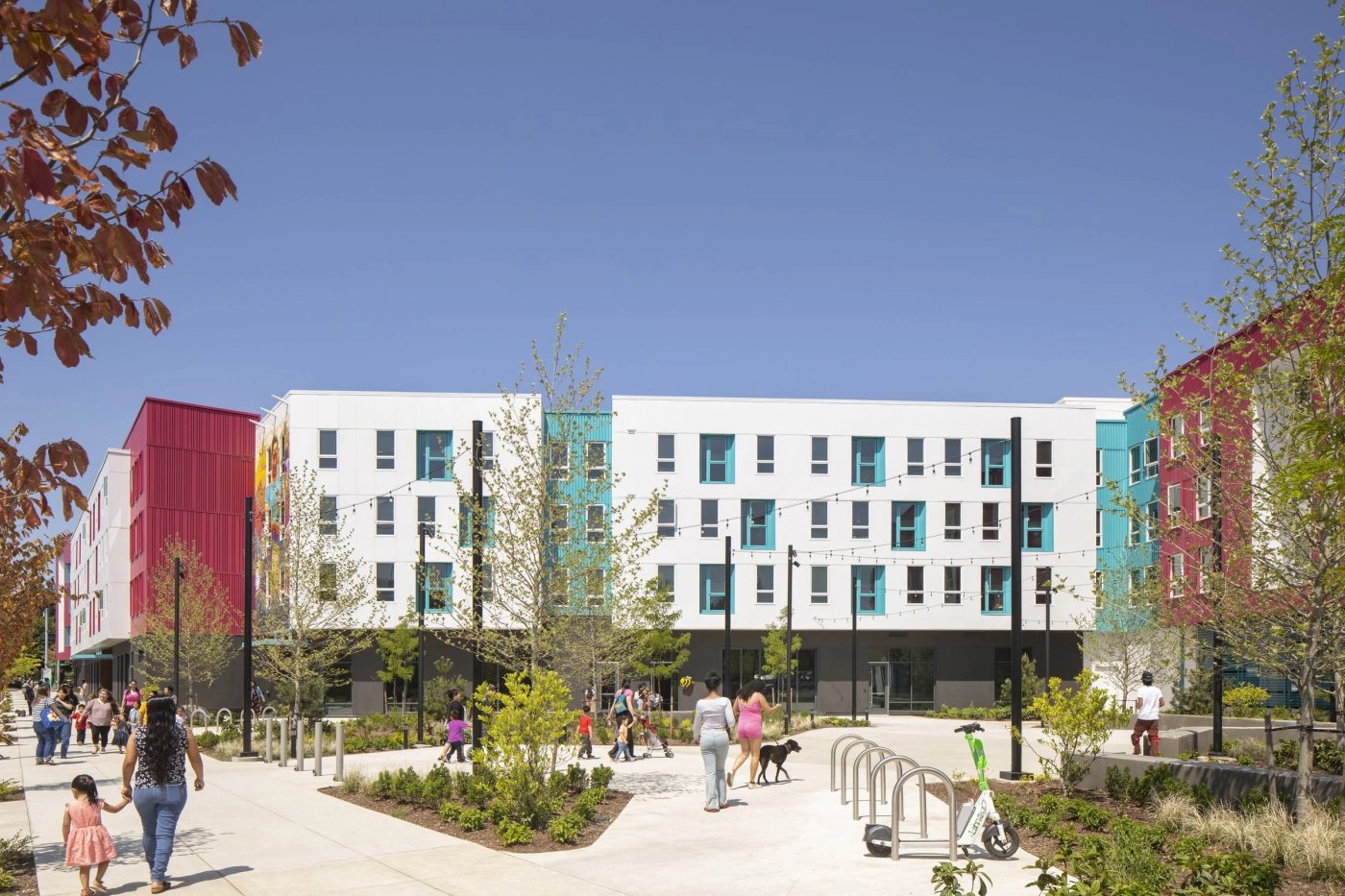 Living Cully apartments with colorful facades and a landscaped plaza